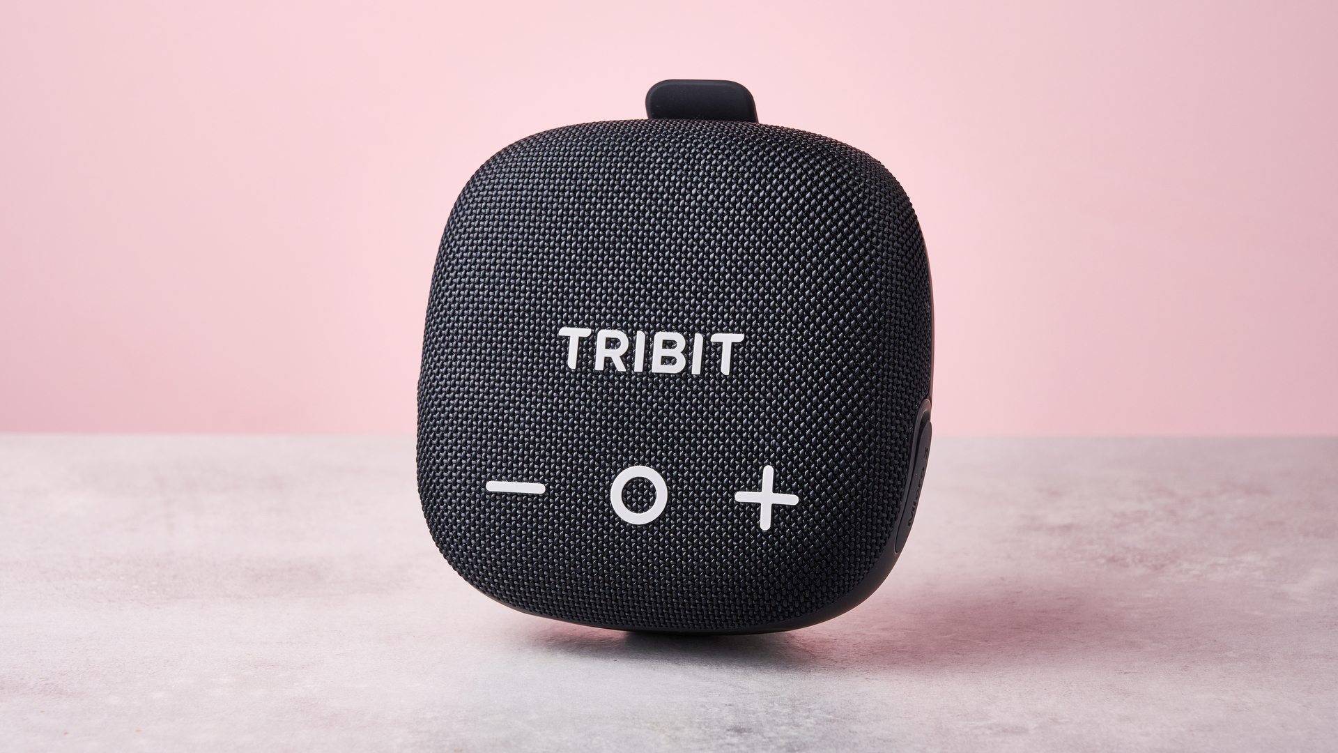 The Tribit Stormbox Micro 3 standing in front of a pink background.