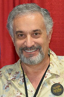 Portrait of a man with greying dark hair and circle beard.